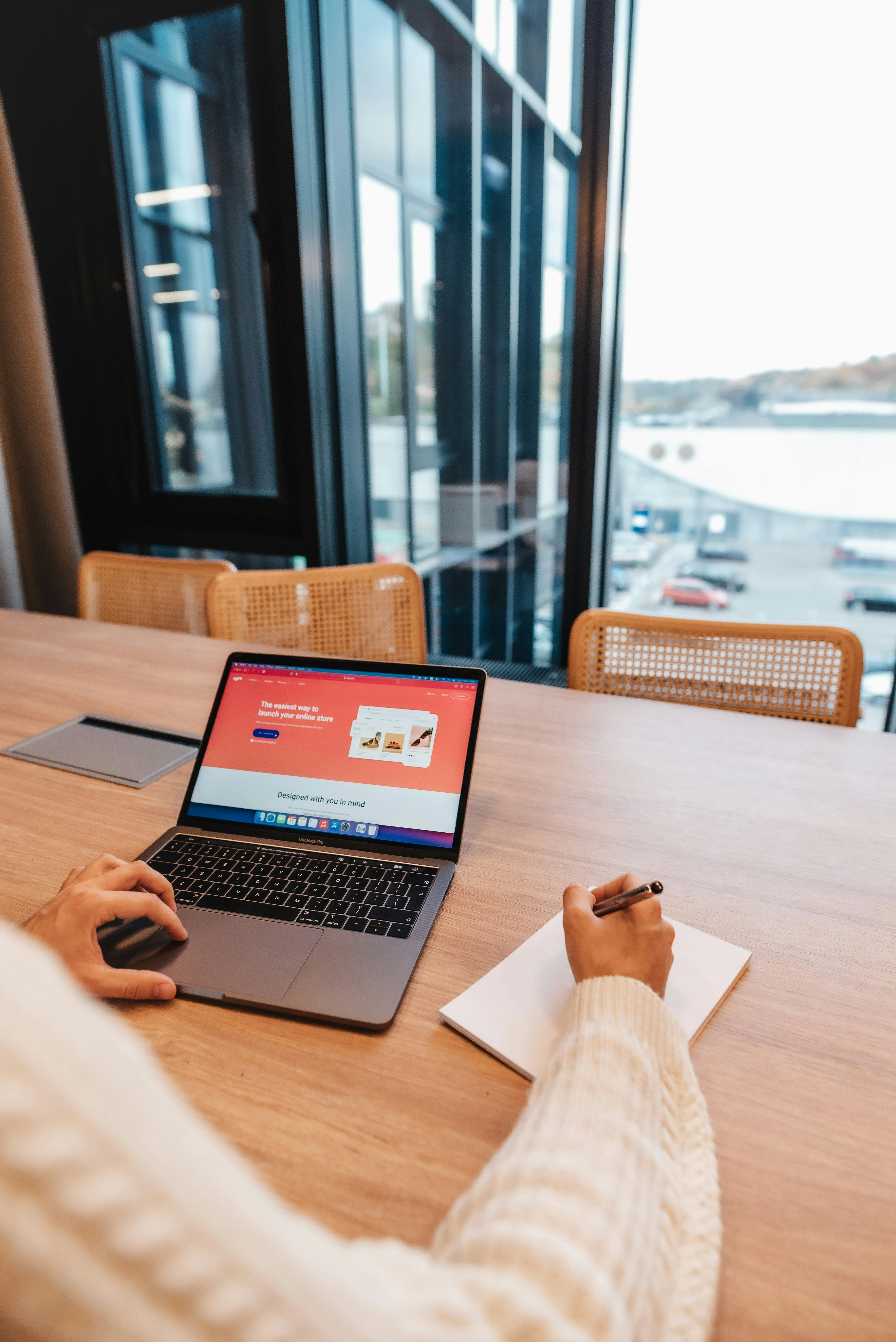 Web designer working on laptop in modern office space - Frost Media Designs