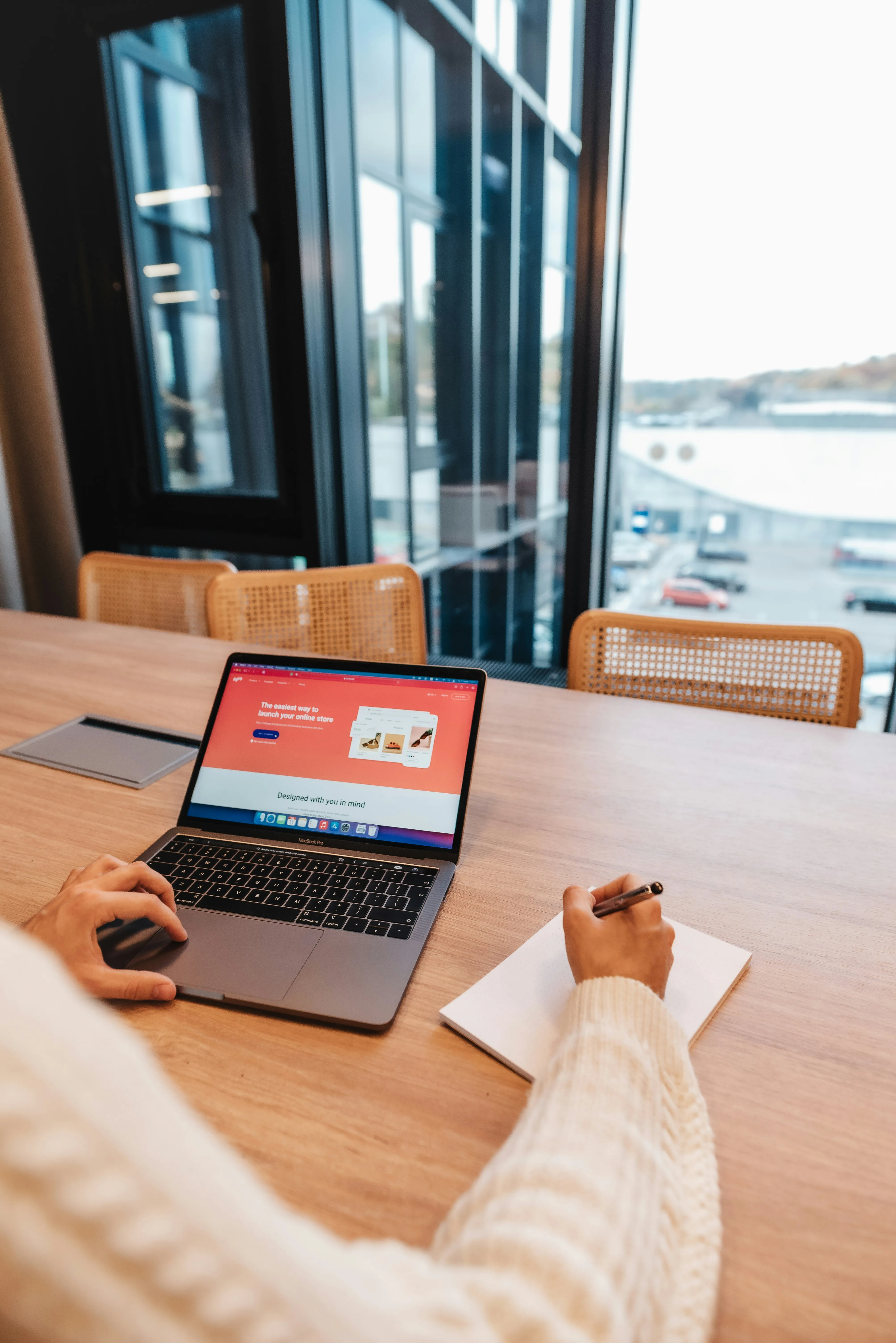 Web designer working on laptop in modern office space - Frost Media Designs